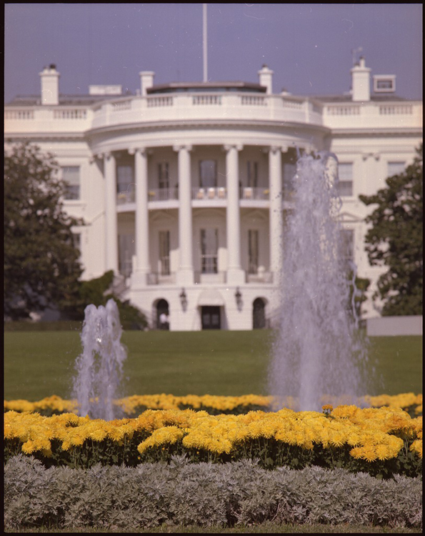 يظهر البيت الأبيض والنوافير والحدائق أمامه.
