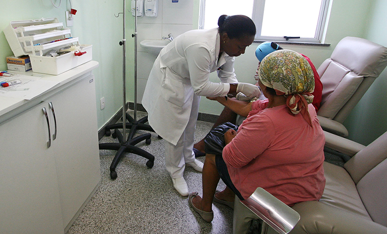 La fotografía muestra a una enfermera administrando una vacuna a un paciente.