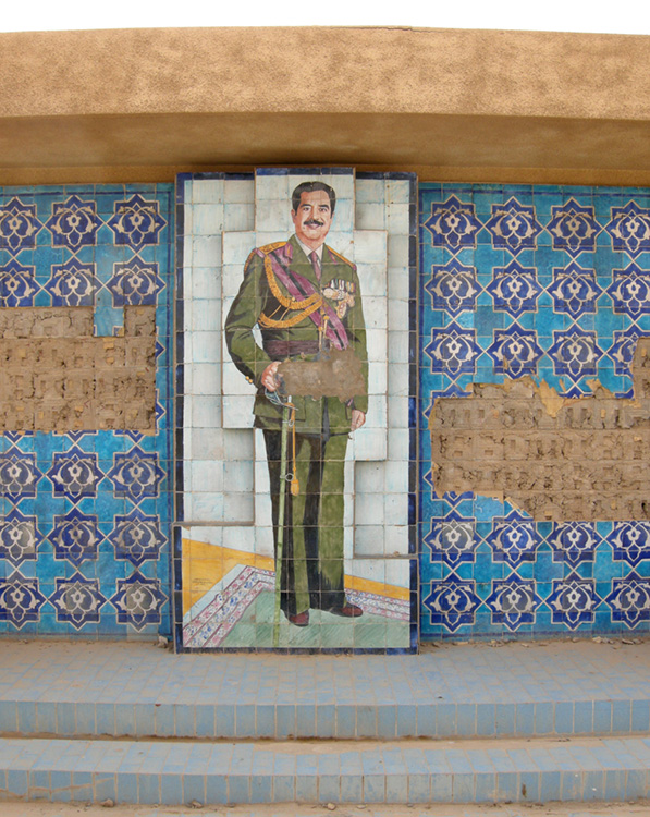 Um mosaico de Saddam Hussein e outras decorações de azulejos são mostrados na parede.