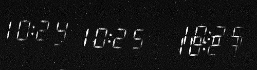 Numbers from a digital clock, blurred, against a black background. From left, 10:24, 10:25, 10:29