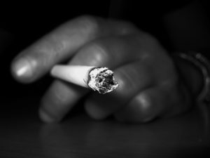 black and white photo of a hand holding a cigarette