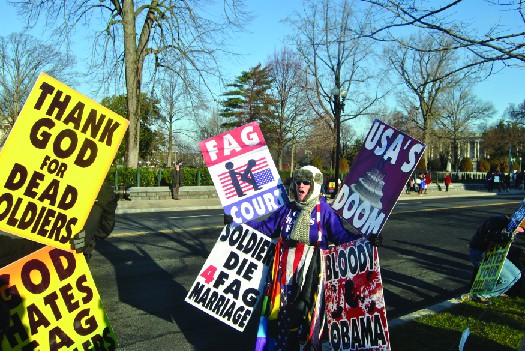A photo of people holding signs. The signs read