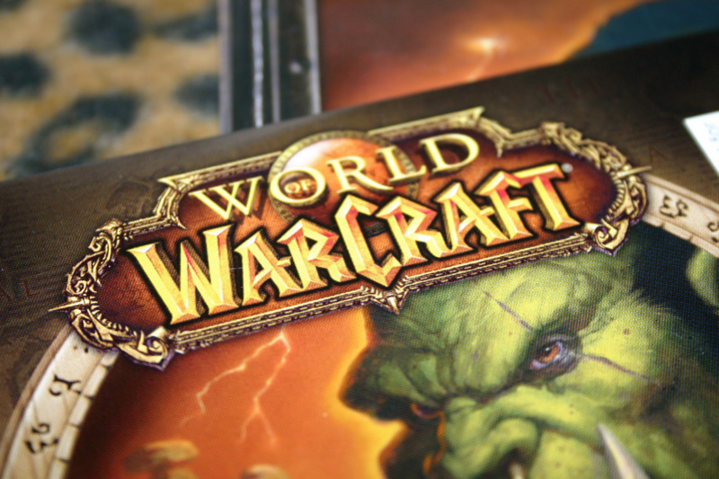 La couverture du jeu vidéo World of Warcraft, y compris un ogre vert à crocs, est présentée ici.