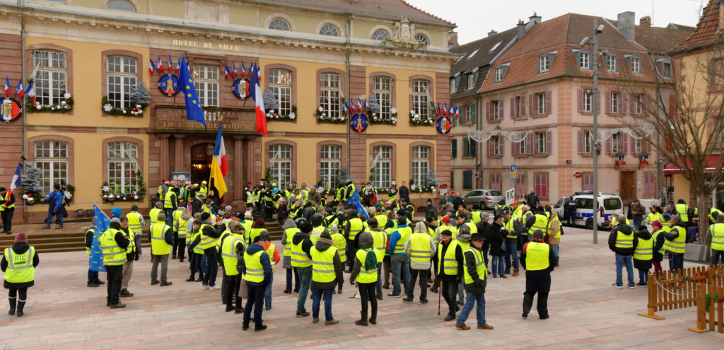 Workers in reflective yellow vests stand around in protest in Belfort, France in December 2018.