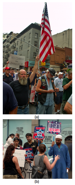 In figure (a) A bearded man holds high a large American flag amidst a protest, a sign reads "no clubhouse for jihadists". In figure (b) People are shown carrying "United We Stand" and "USA" signs.