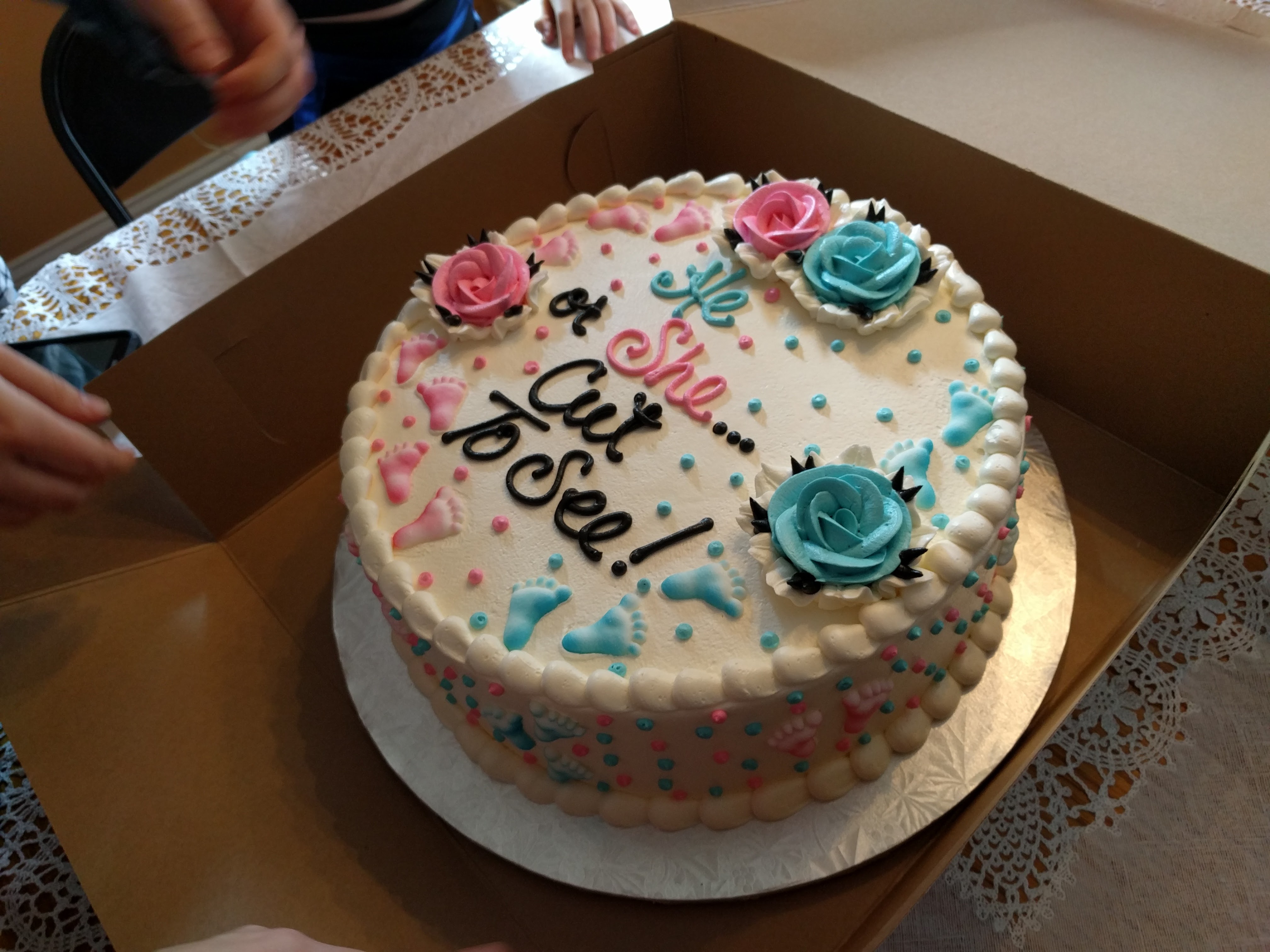 Shown here is a gender-reveal cake that reads "He or she...cut to see!".