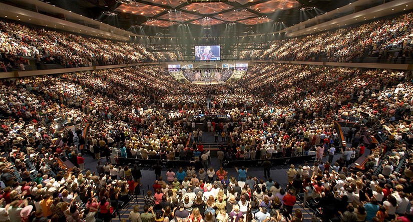 A photo of thousands of people in a stadium during a megachurch ceremony.