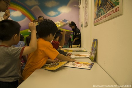 Young students looking at picture books at a table.