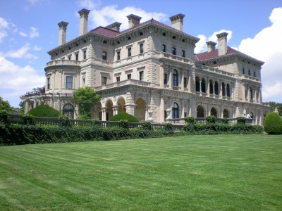 A mansion with a large green field built during the Gilded Age.