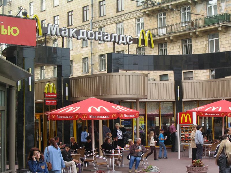 This picture is of the outside of the fast food chain McDonald's. "McDonald's" is spelled using the Cyrillic alphabet since this McDonalds is located in Russia.