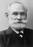 Ivan Pavlov in his older years, with a white beard, wearing a suit and tie.