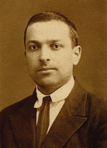 Vygotsky wearing a suit and tie. He has short brown hair, dark features, and no facial hair.