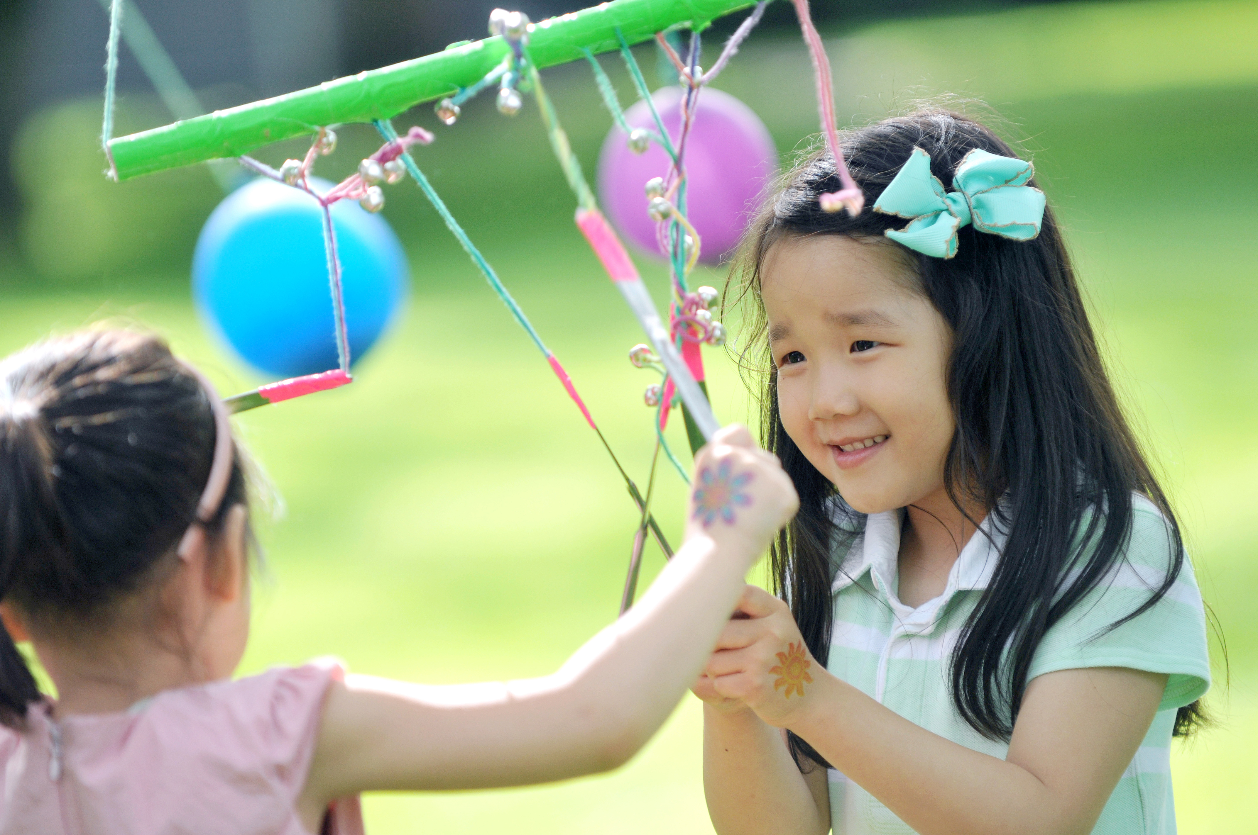 Young girls happily playing with ribbon wands.