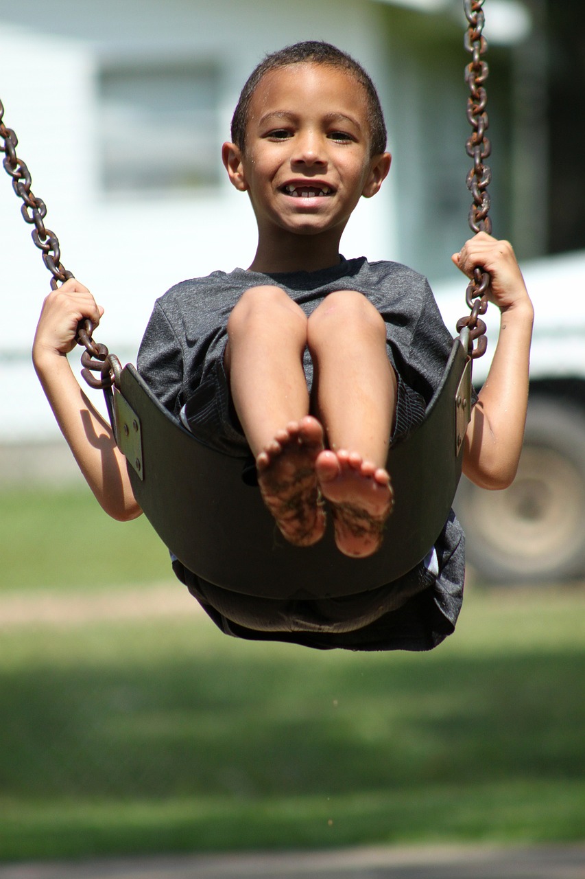 smiling boy on a swing with gap in teeth
