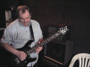 middle-aged man playing the electric guitar.