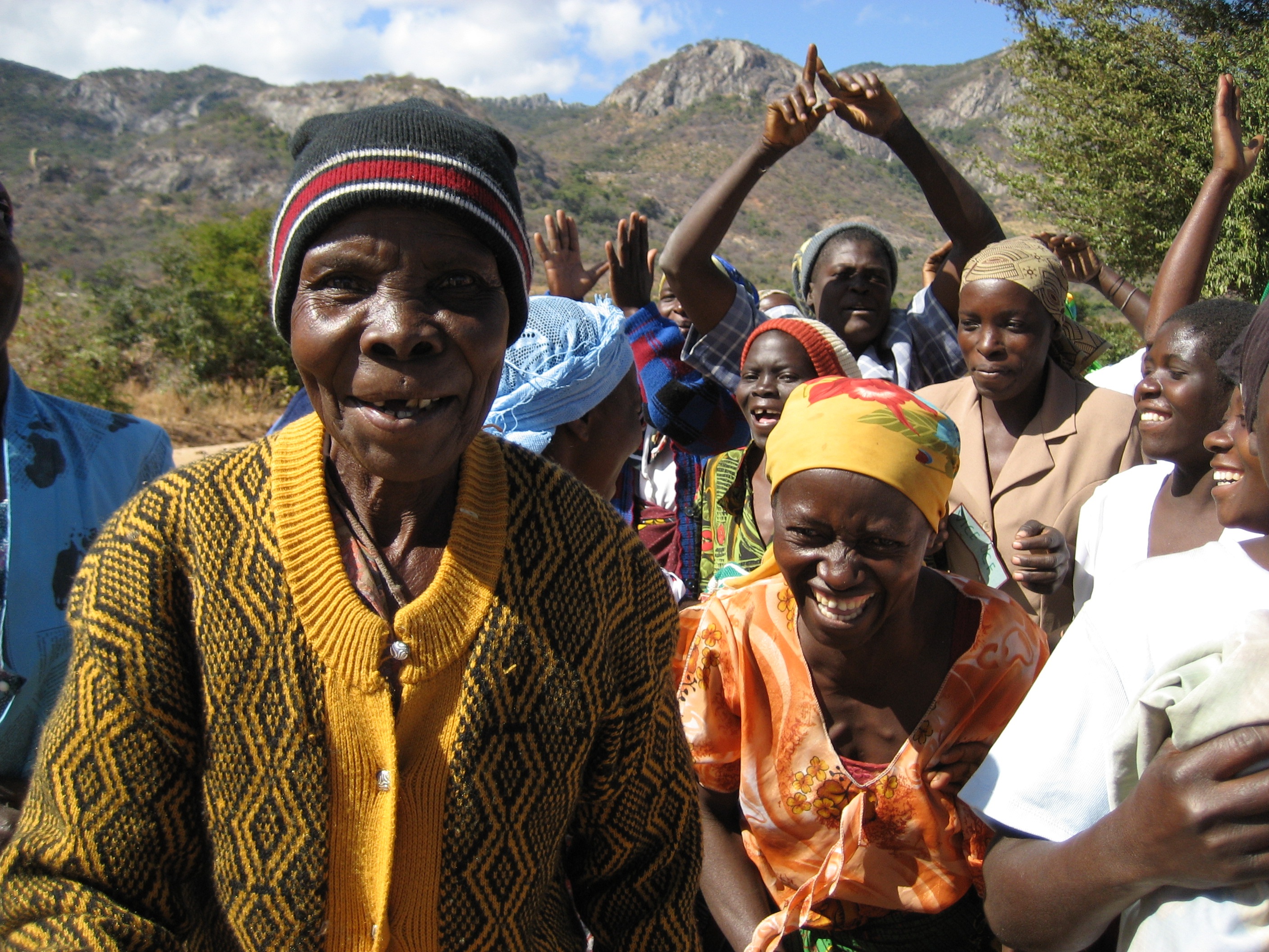Smiling African grandmother with other women enjoying a walk in the sunshine.