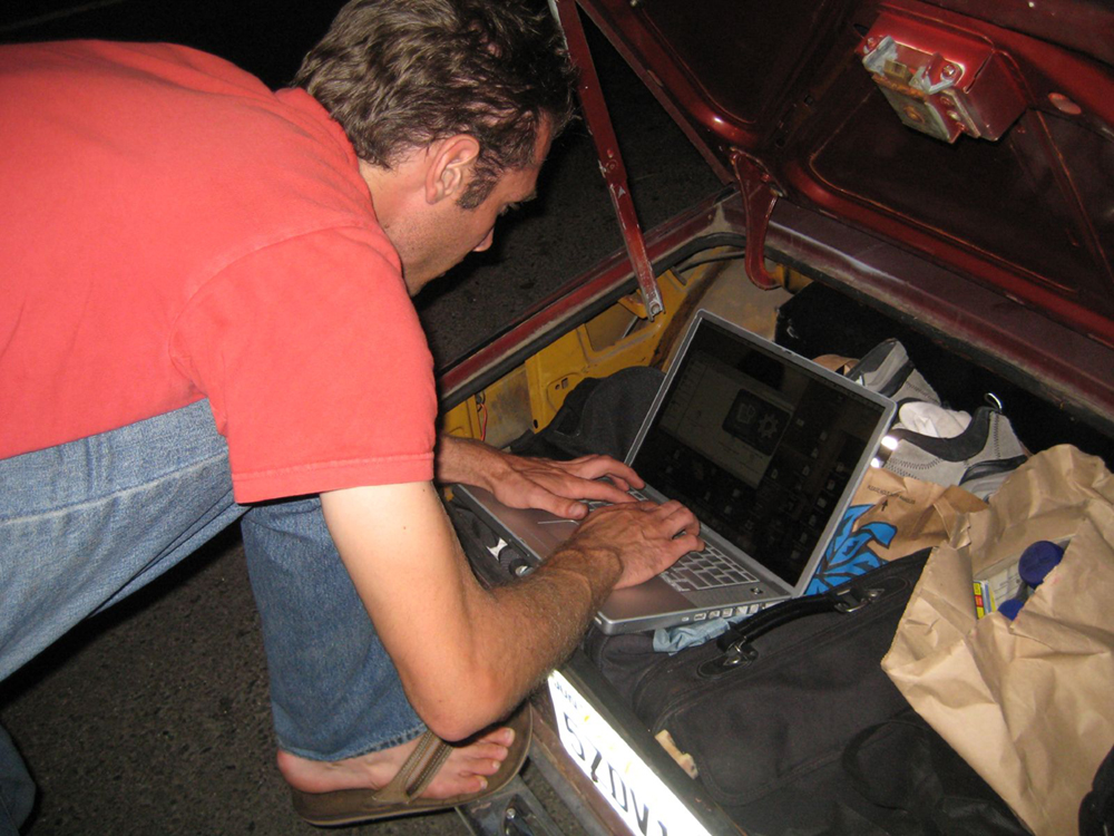 رجل يتكئ على جهاز كمبيوتر محمول، يكتب في الصورة هنا.