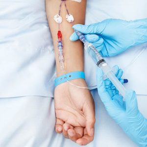 Cierre de un brazo de paciente equipado con goteo intravenoso.” title="Cierre de un brazo de paciente equipado con goteo intravenoso.