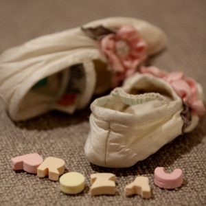 Image of baby booties and the word 'Prozac' spelled out in candy letters." title="Image of baby booties and the word "Prozac" spelled out in candy letters.