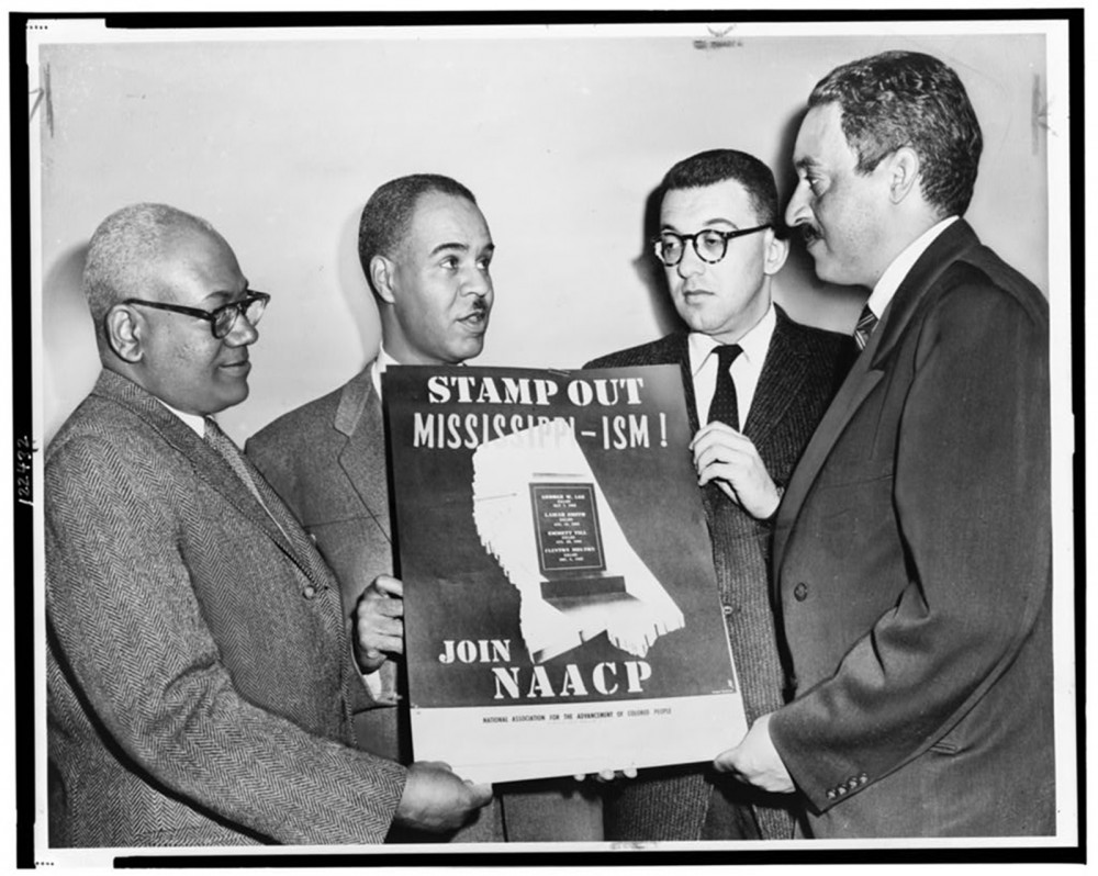 Quatre hommes tenant une affiche sur laquelle on peut lire Stamponnez le Mississippi-ism et rejoignez la NAACP. La NAACP était une organisation centrale dans la lutte pour mettre fin à la ségrégation, à la discrimination et à l'injustice fondées sur la race. Les dirigeants de la NAACP, dont Thurgood Marshall (qui deviendrait le premier juge afro-américain de la Cour suprême), arborent une affiche dénonçant les préjugés raciaux dans le Mississippi en 1956.