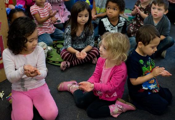 children sitting on the floor with their hands cupped
