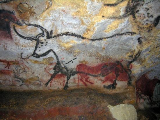 Photograph of just one surface with cave art at Lascaux Cave. The most prominent piece here is the Second Bull, found in a chamber called the Hall of Bulls. Smaller cattle and horses are also visible.