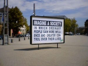 Signo diciendo: Imagínese una sociedad en la que la gente común gane más influencia y mayor control sobre sus vidas.