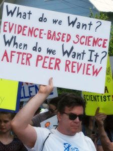 Demonstrator with a Sign Saying He Wants Evidence-Based Science