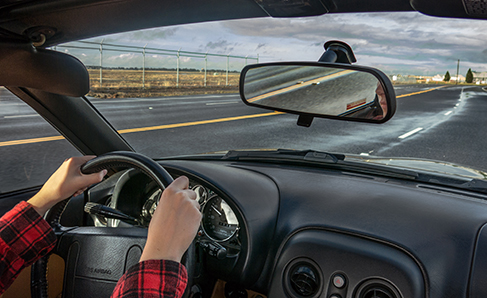 Una fotografía muestra a una persona manejando un automóvil.