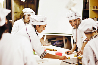 Una fotografía muestra a varios chefs preparando comida juntos en una cocina.