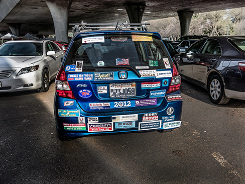 تُظهر الصورة الجزء الخلفي من سيارة مغطاة بالعديد من الملصقات الواقية من الصدمات.