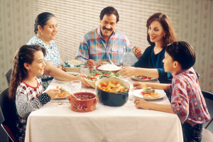 foto de una familia sentada en la mesa cenando juntos