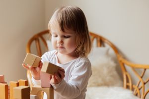 Photo of a young child playing with wooden blocks