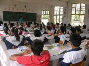 una foto de niños de secundaria sentados en escritorios en un aula