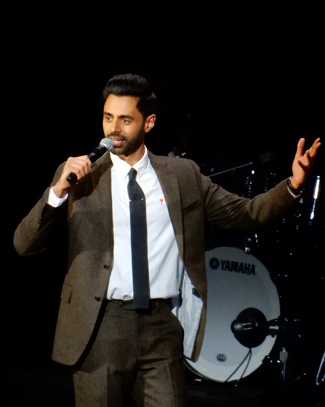 comedian Hasan Minhaj doing a stand up comedy routine