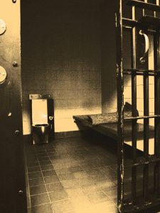 Stylized photograph of a jail cell.
