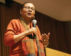 Photograph of bell hooks speaking with a microphone in her hand.