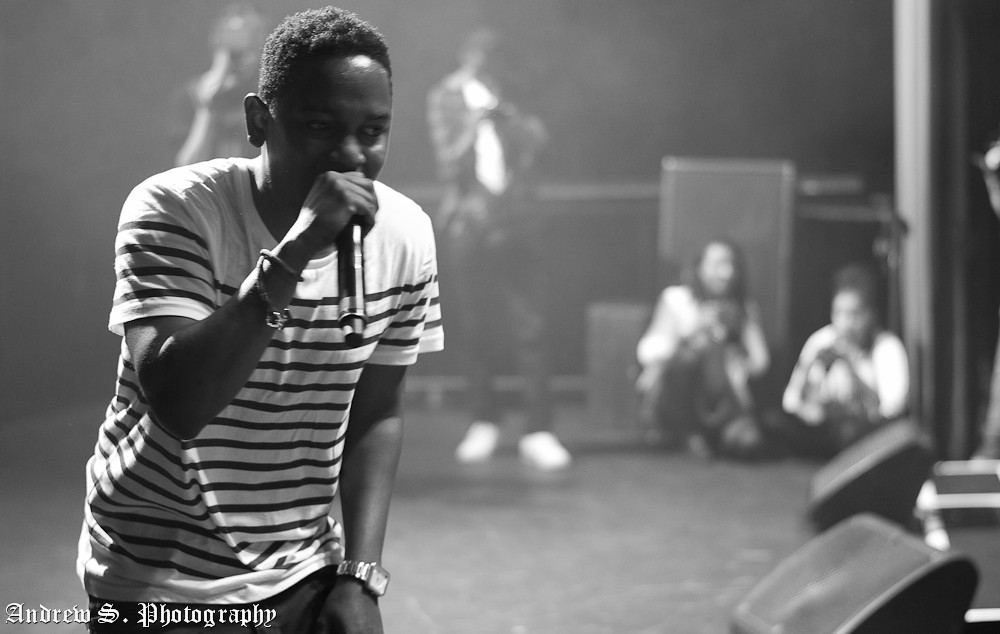 Kendrick Lamar holds a microphone close to his mouth