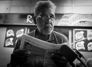Man-reading-a-newspaper-by-Nicolas-Alejandro-300x220.jpg