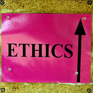Red ETHICS sign posted on a corkboard