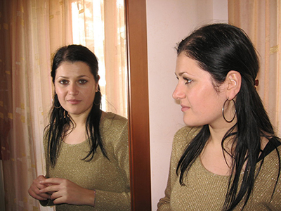 Woman looking at her reflection in a mirror