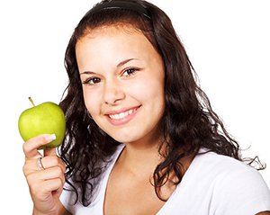 Woman smiling and posing with an apple