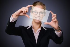 Businesswoman holding up translucent paper in front of her face