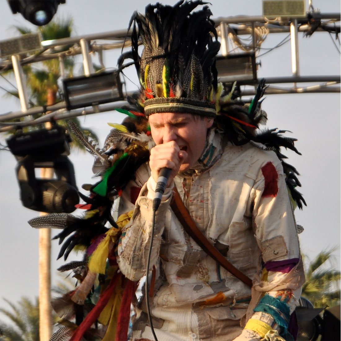 A photograph of singer Jonsi performing at Coachella in what appears to be Native American headdress.