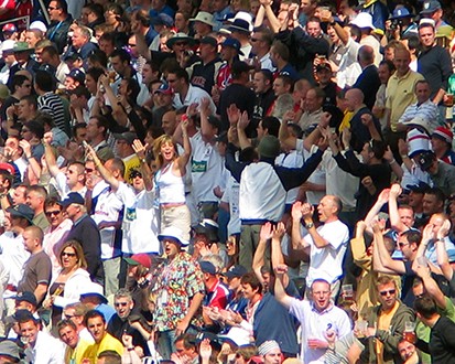 Large group of cheering fans in a stadium.