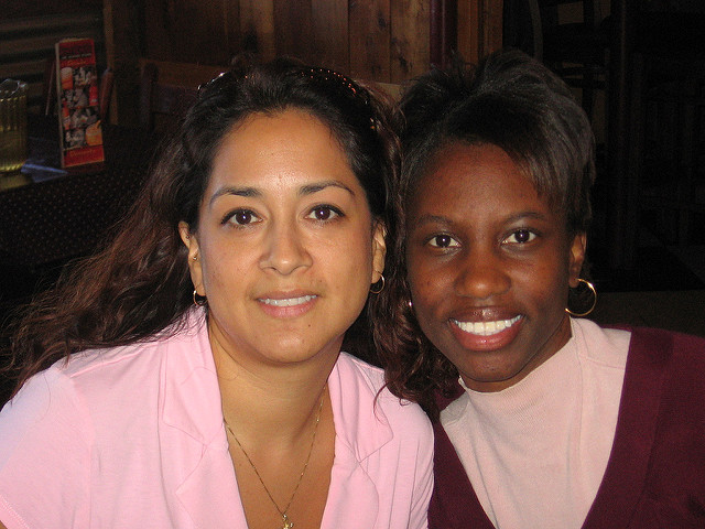 Two people of different races posing for a picture.