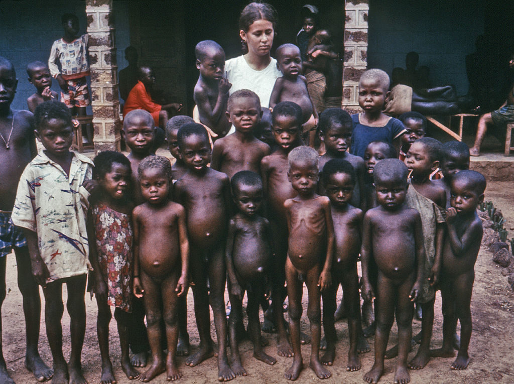 A large group of starving children is pictured.