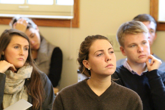 Photo of five students seated in class. All look deep in thought.