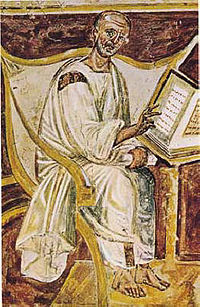 Painting detail of a bald man in white robes and bare feet, wearing glasses, seated in a white chair reading a book