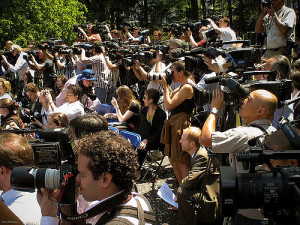 Photo of a large group of photographers and news cameras, all aimed at something out of frame